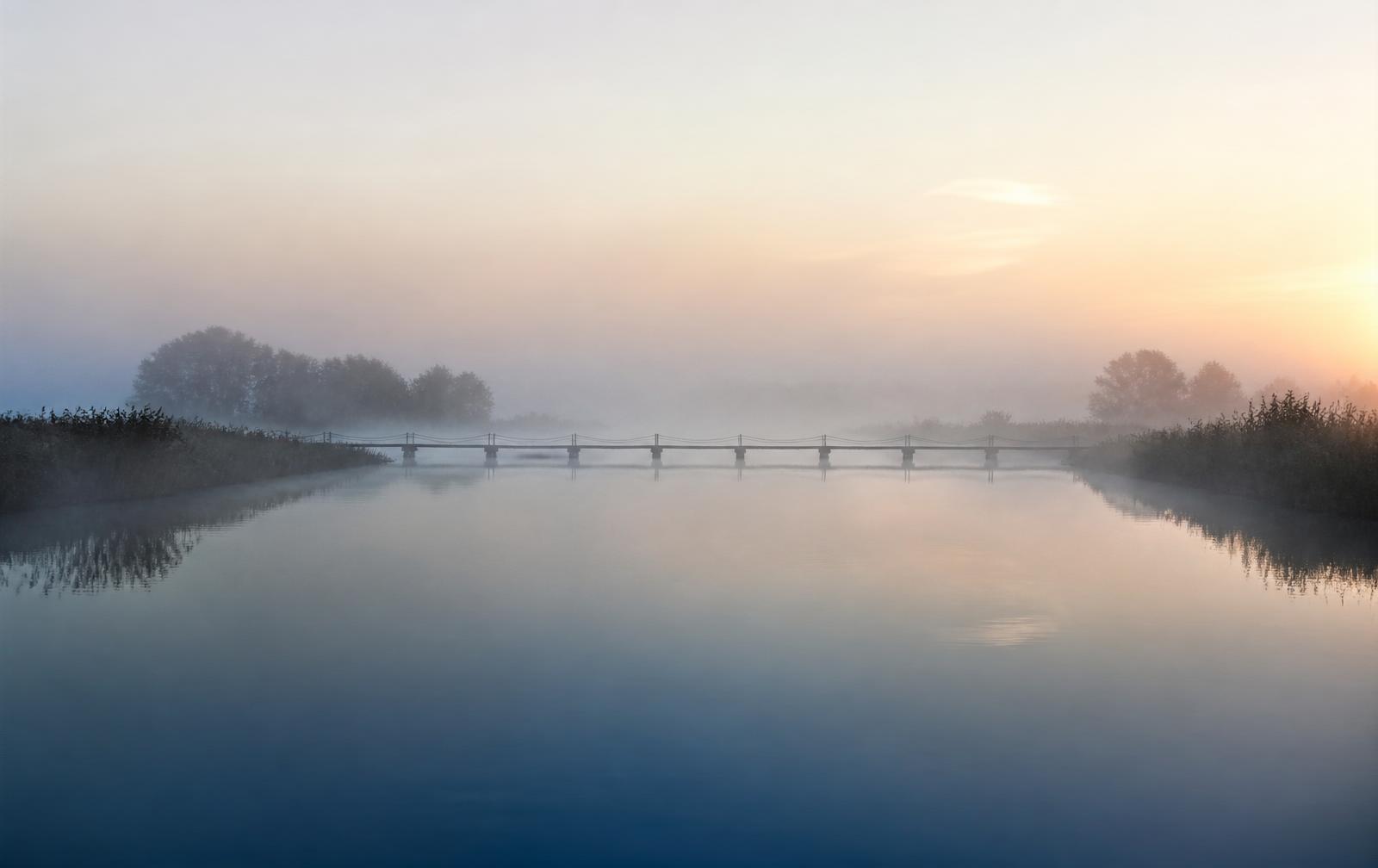 Ponte sobre um lago tranquilo ao amanhecer